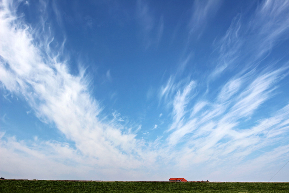 Himmel mit Wolken über Norderney und dem Deich