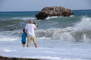 Ein junger Vater erfreut sich mit seinem Sohn an den Wellen