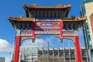Tor am Eingang zu Chinatown im Newcastle mit dem Fußballstadion St. James Parc