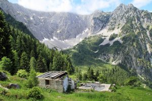 Ruinen der verfallenen Jöchlalm am Heuberg in Österreich mit Blick auf die Nordwände des Zahmen Kaisers in Tirol