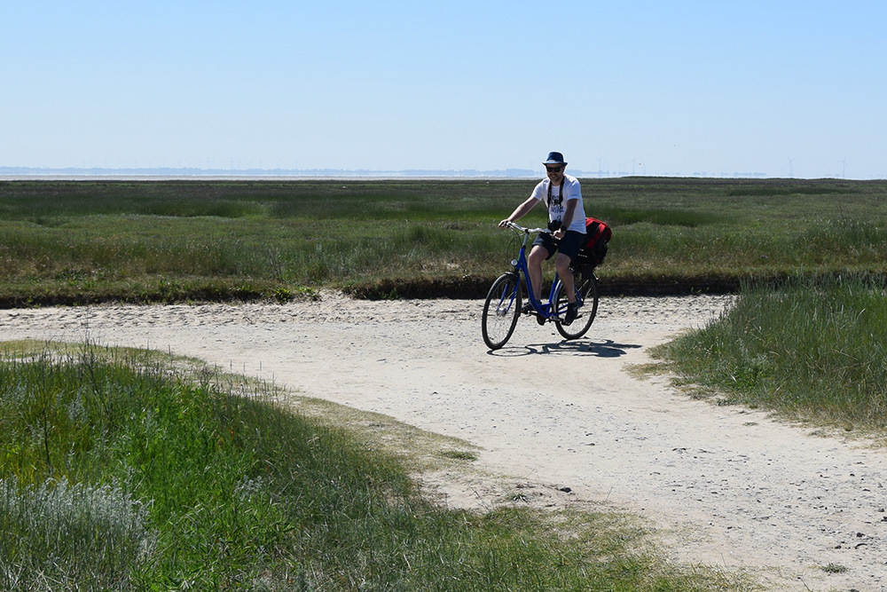 Ein Fahrradfahrer fährt mit einem Fahrrad über die autofreie Insel Wangerooge
